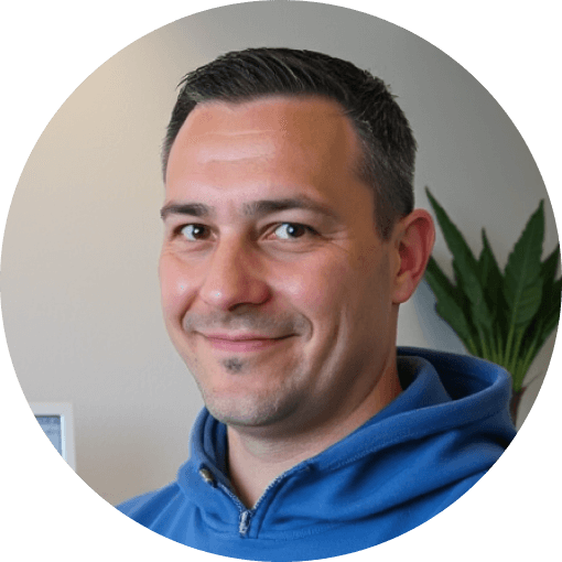 Person mit blauem Hoodie und Pflanze im Hintergrund lächelnd